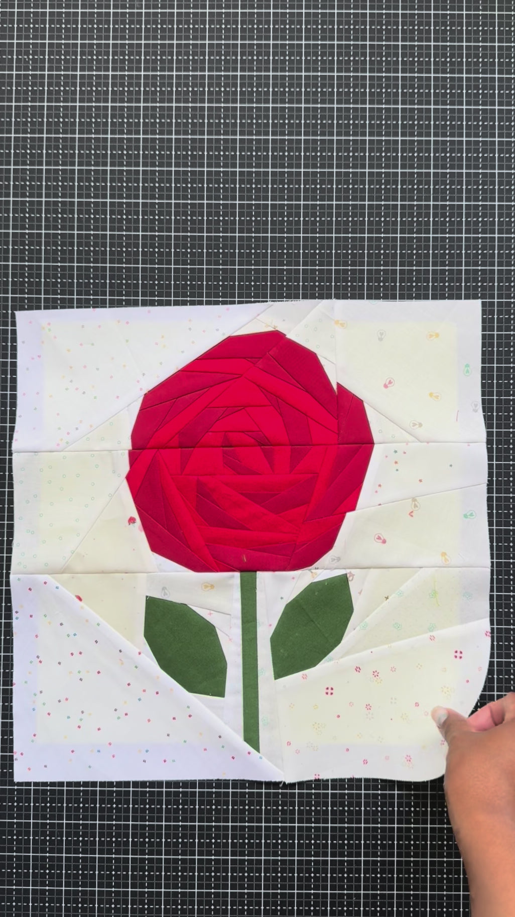 Video of three quilt blocks with rose designs on a grid background